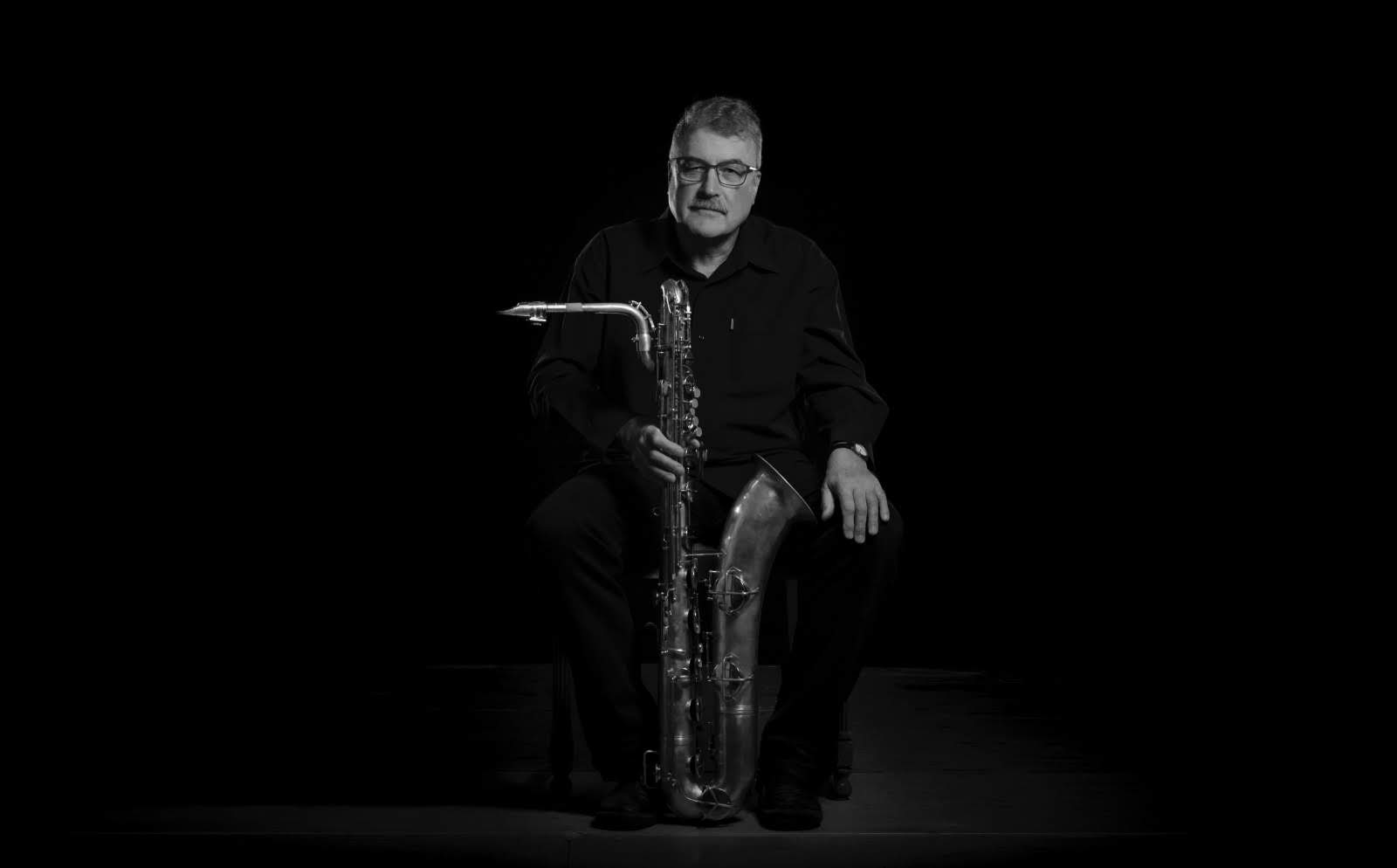 Dieter Mross mit Saxophon vor heller Kulisse
